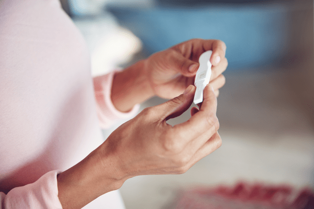 woman holding a pregnancy test