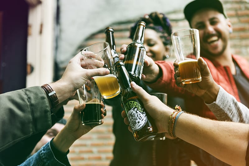 group of people doing cheers with drinks