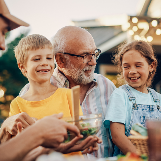 man with hearing aid hugging his grandchildren