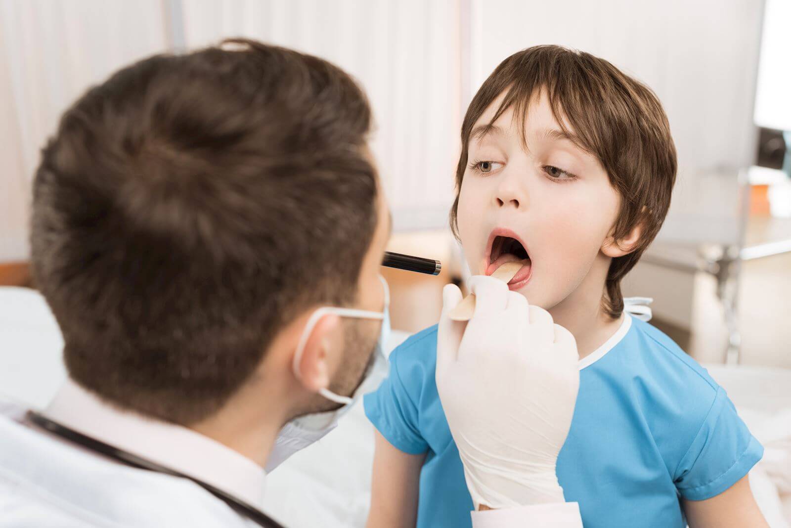 doctor examining inside child's mouth