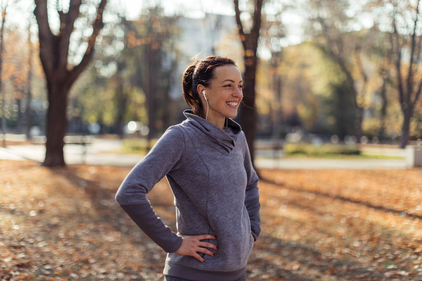 woman smiling while exercising in park