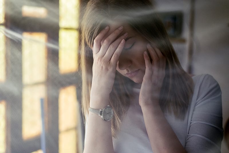 woman holding her head in pain