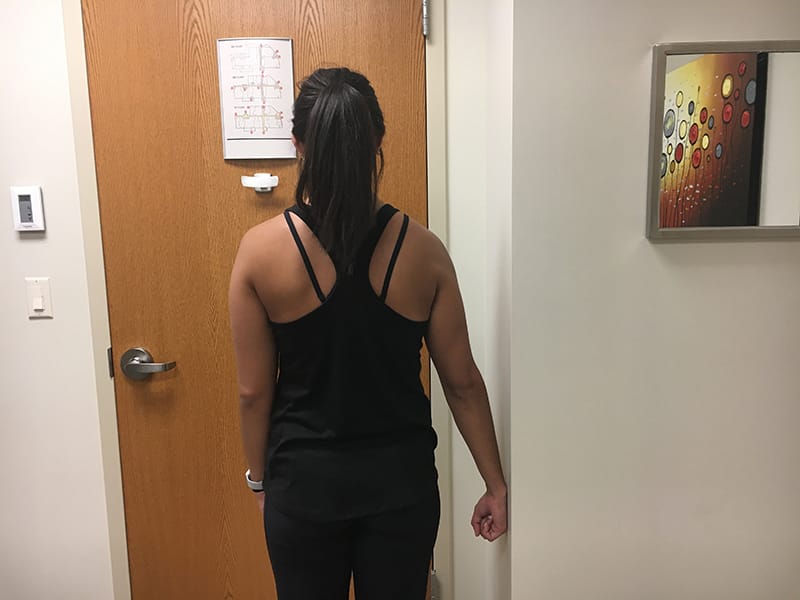 Woman facing away from camera showing shoulder isometrics abduction