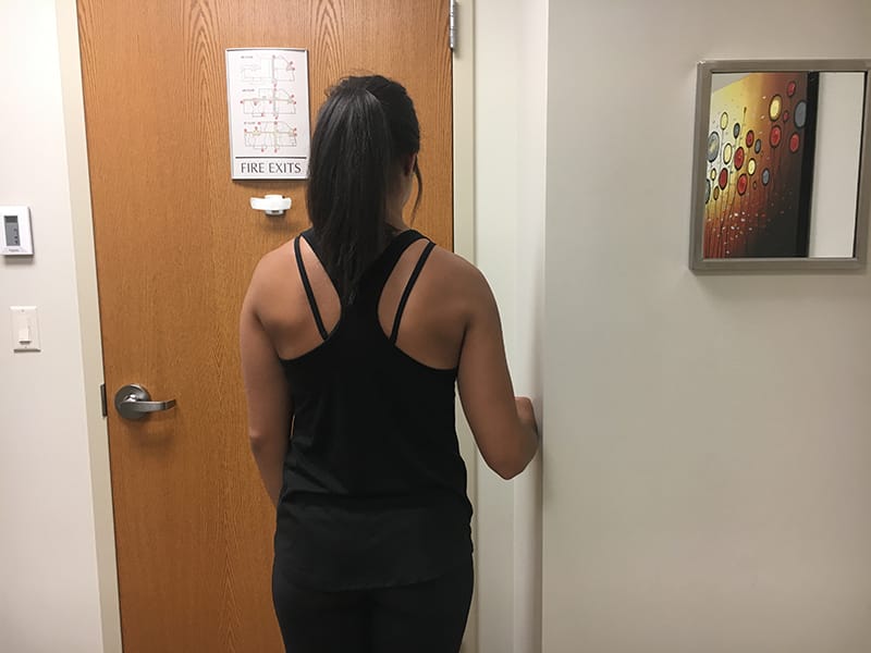 Woman facing away from camera showing shoulder isometrics external rotation