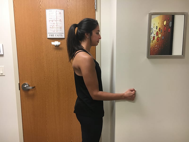 Woman facing sideways showing shoulder isometrics internal rotation