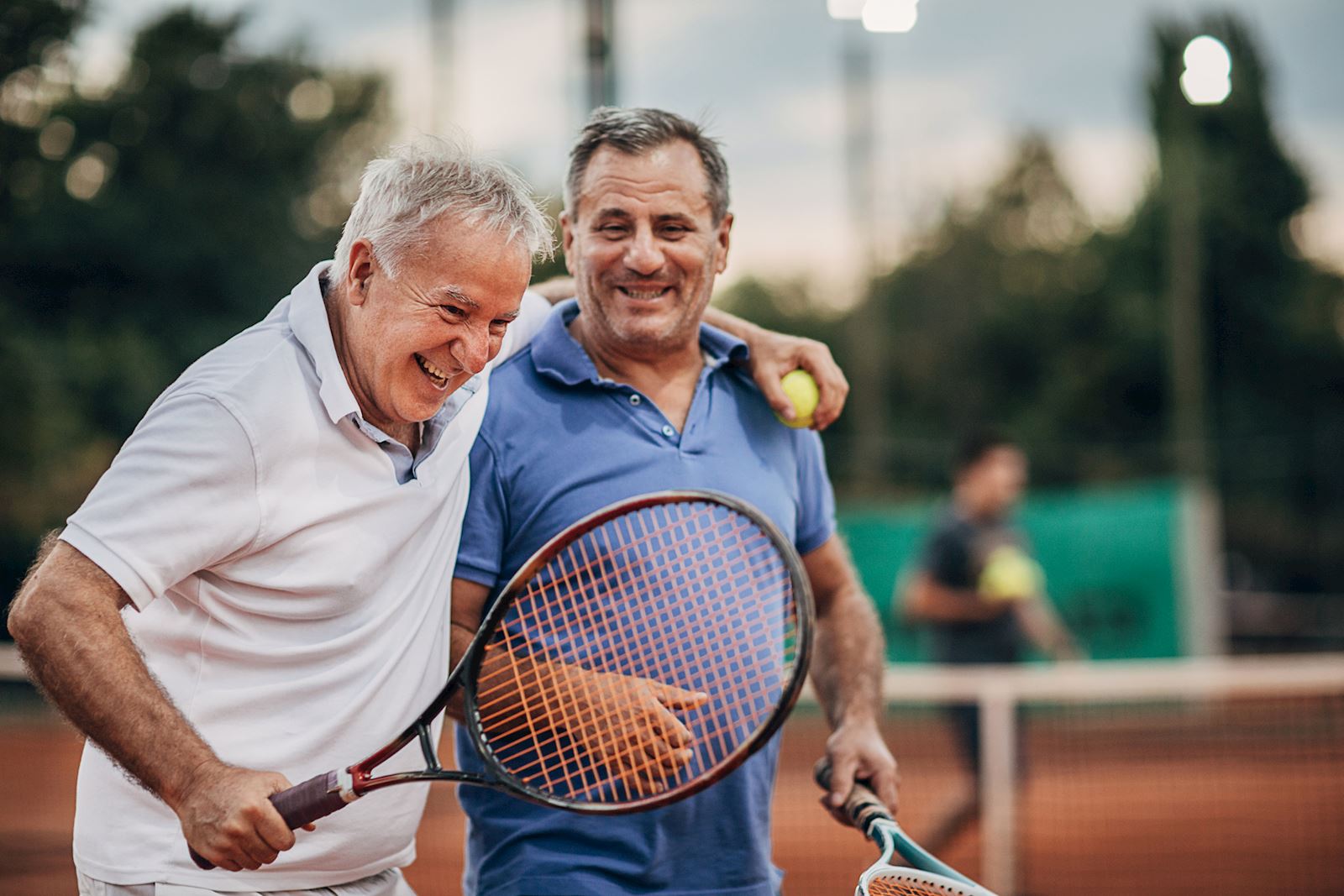 two men playing tennis and laughing