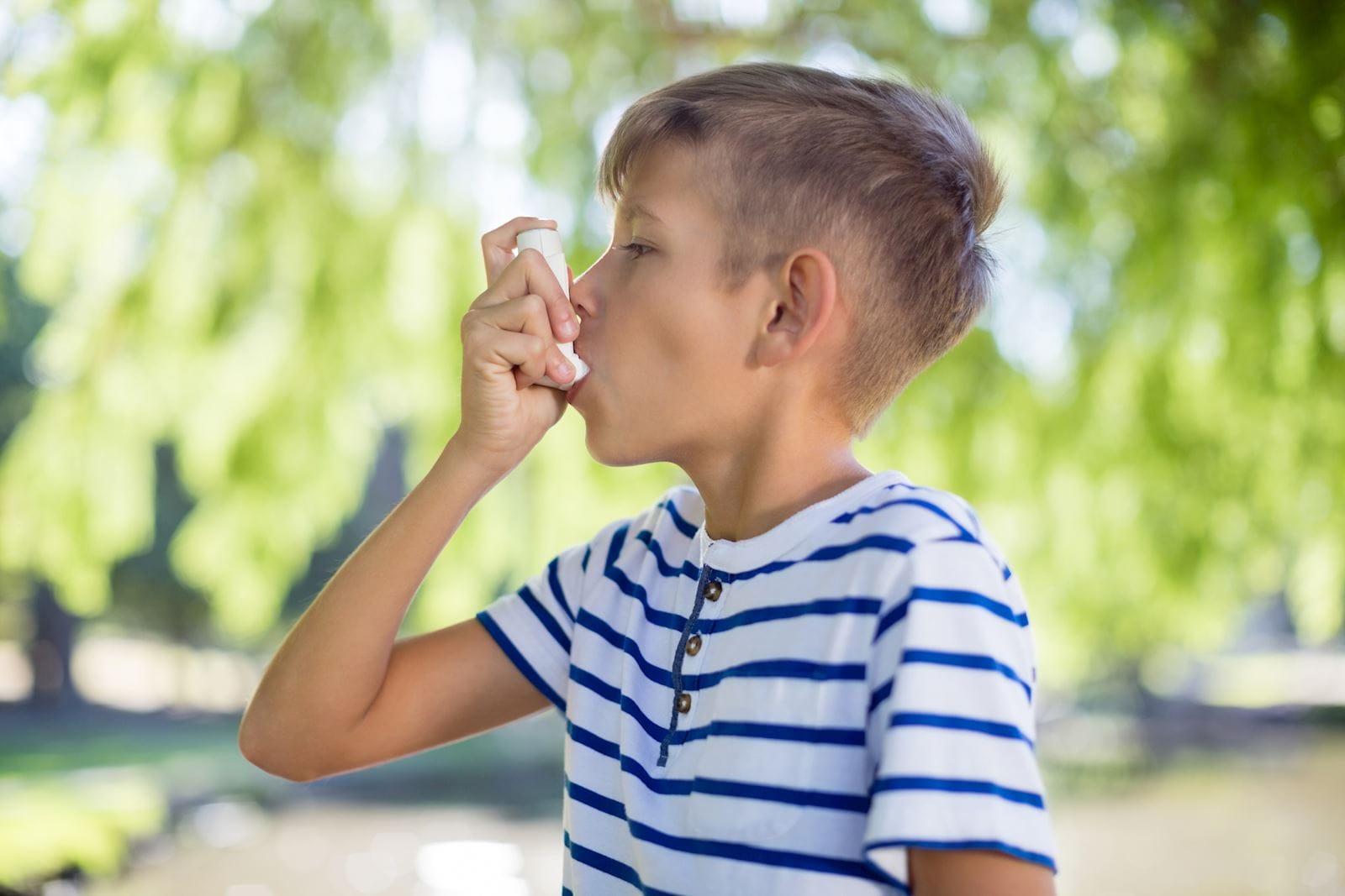 young boy using his inhaler