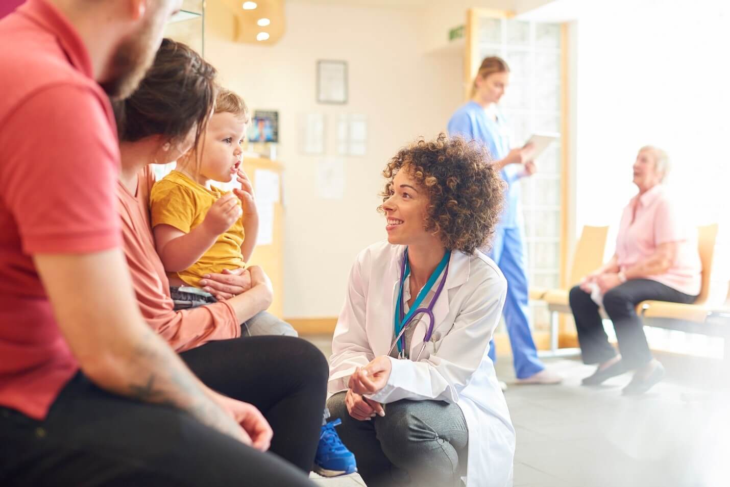 pediatrician talking with young patient and parents