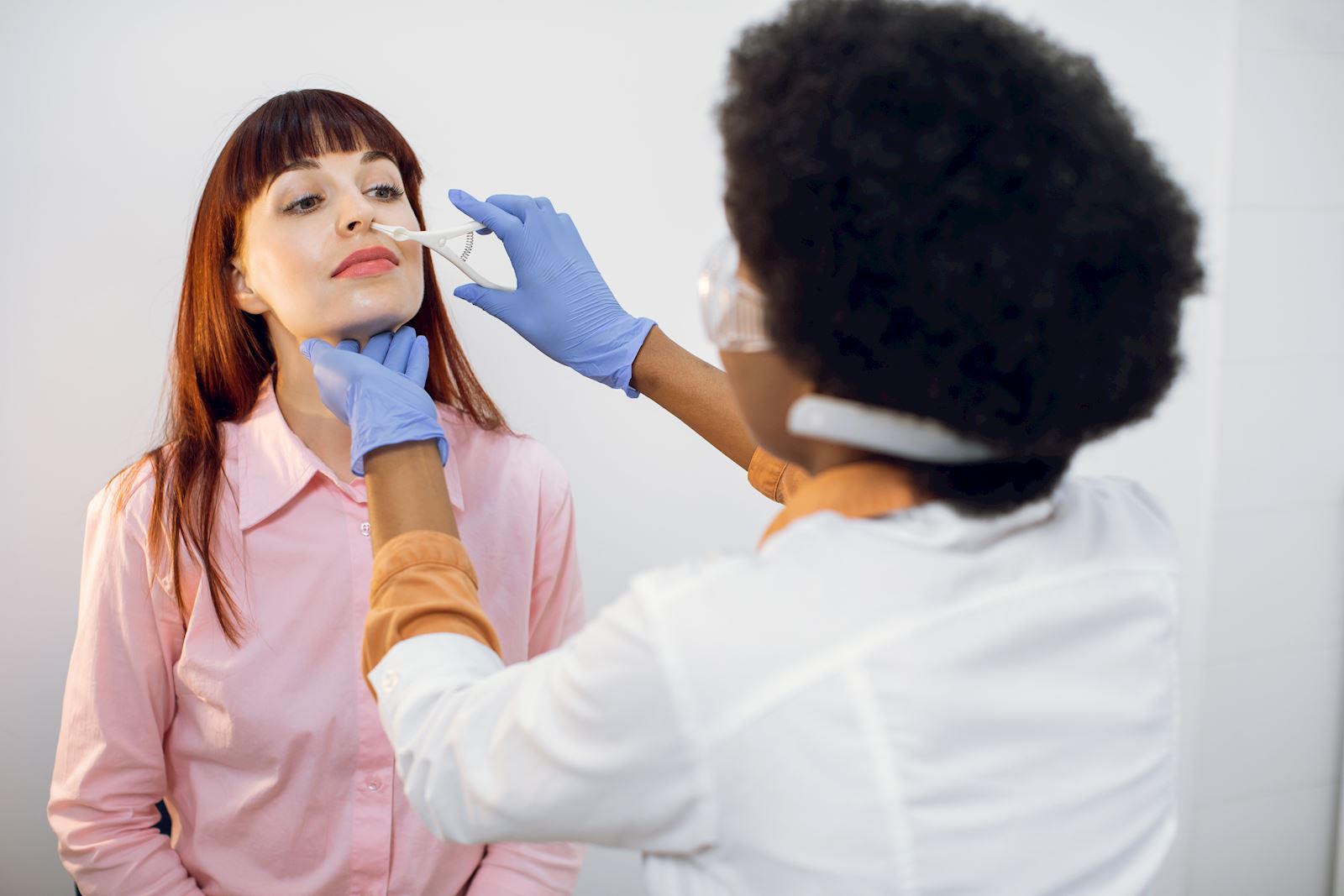 Women having her nose inspected by healthcare provider
