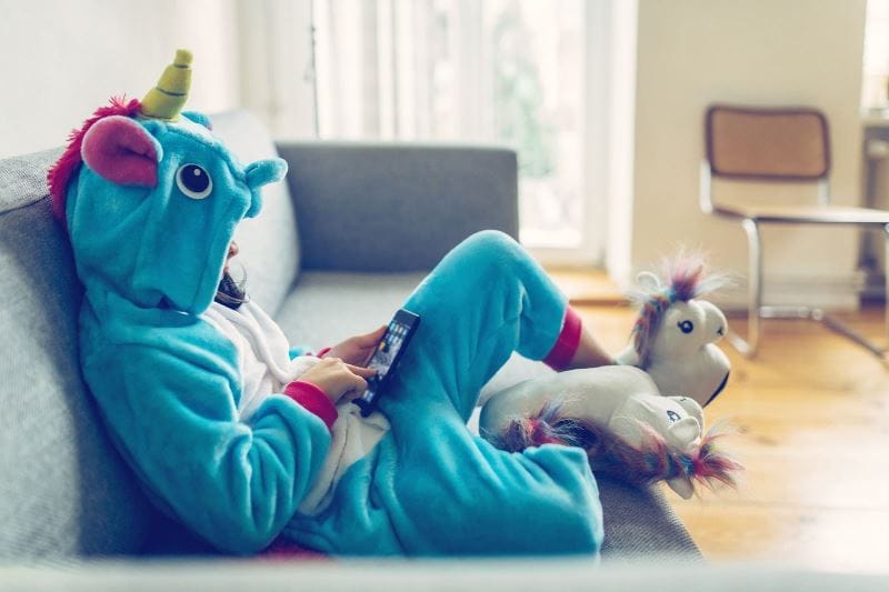 kid playing on their tablet on the couch