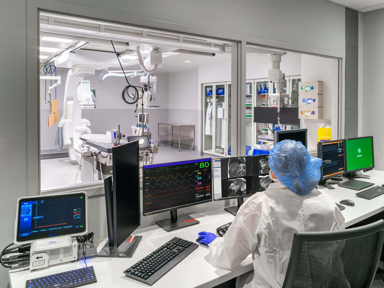 healthcare worker looking through cath lab window