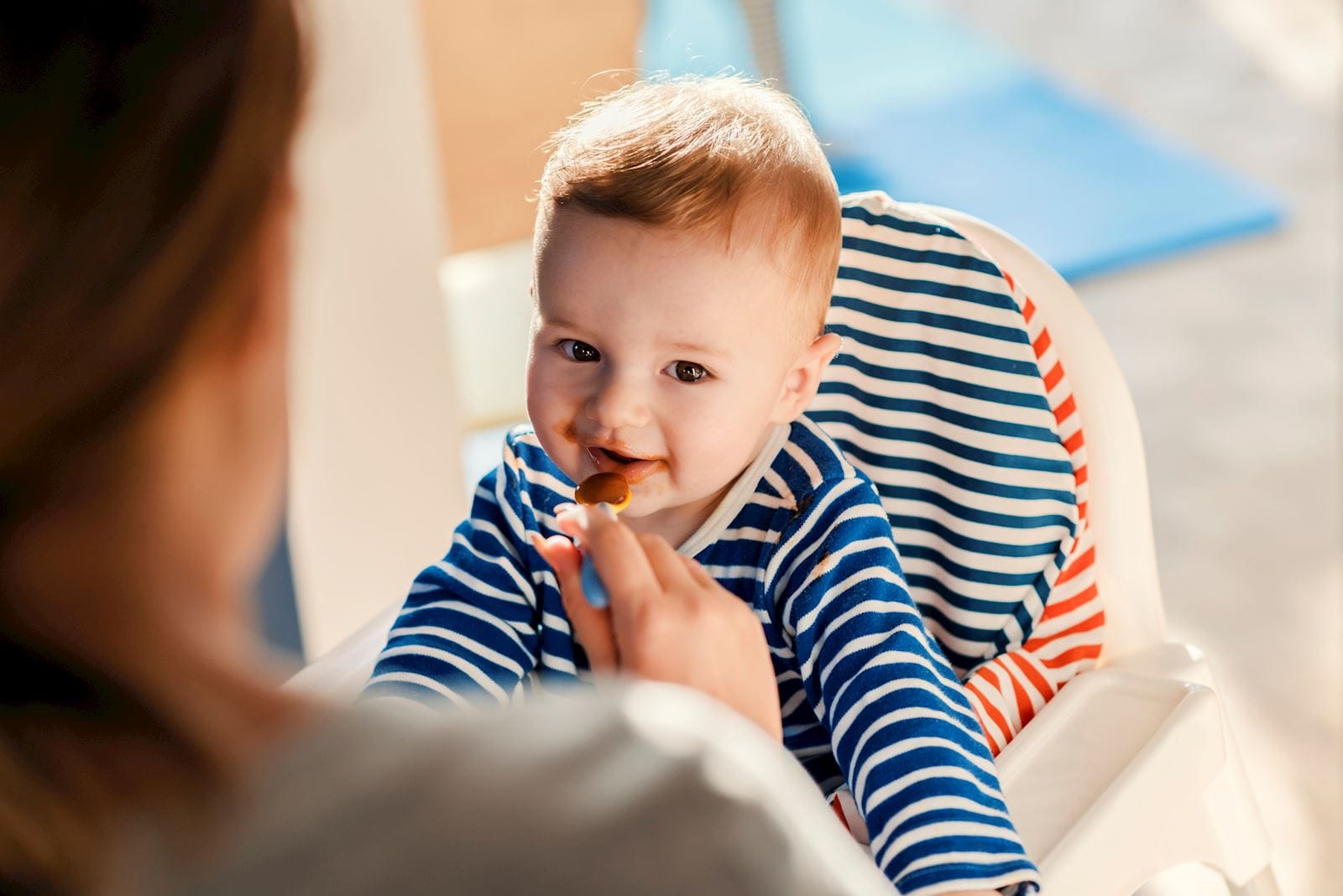 baby eating in highchair