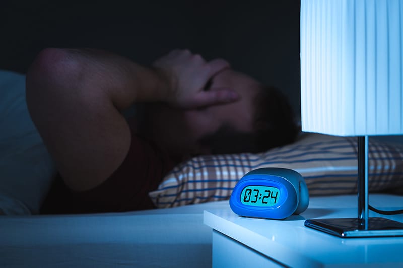 man in bed, trying to sleep