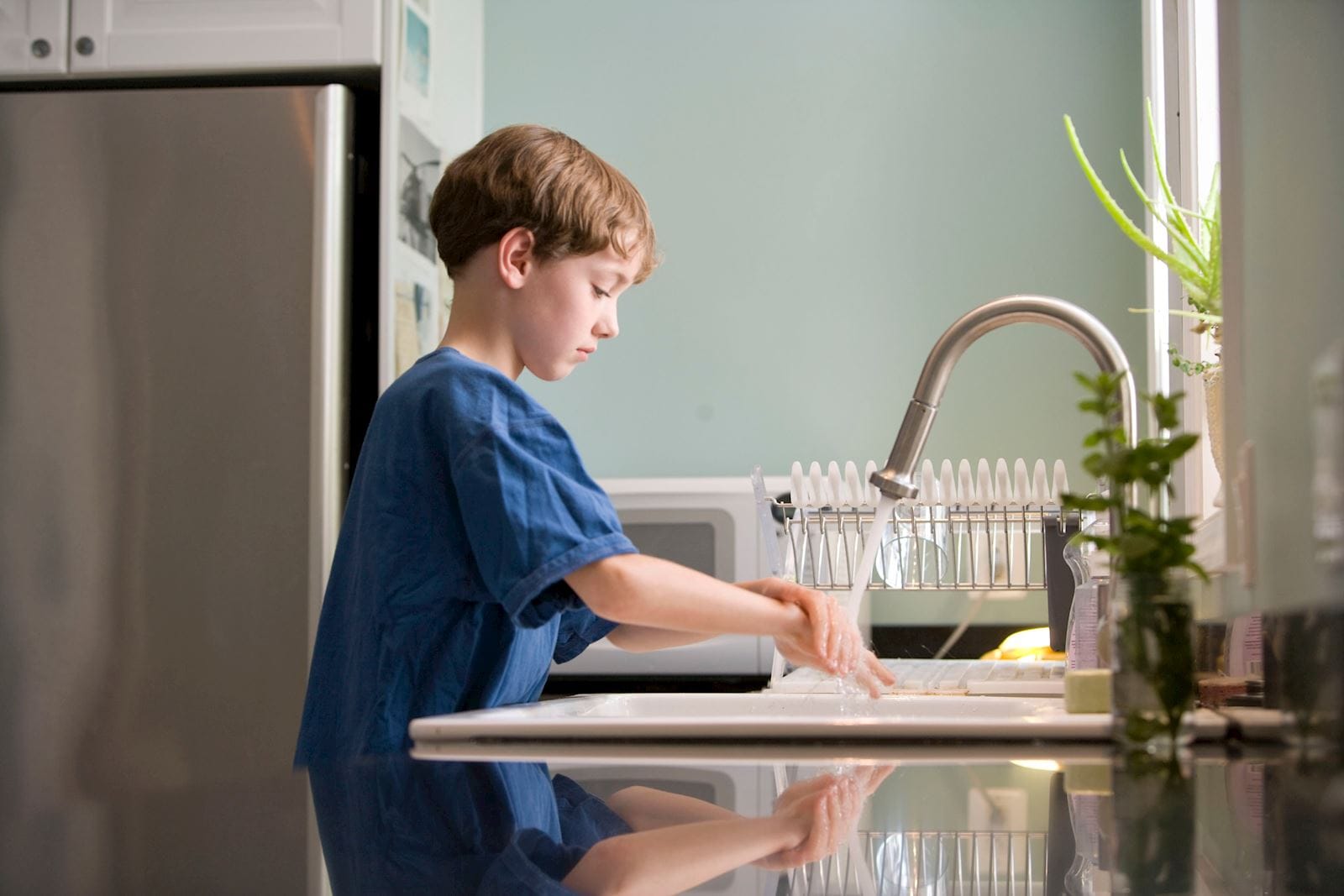 young boy washing his hands
