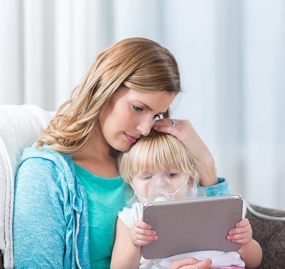 mother comforts daughter, who is wearing a breathing mask