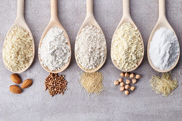 five spoons containing different nut flours