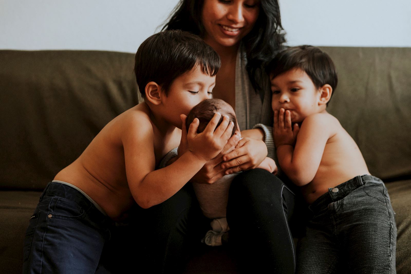 baby held by mom, surrounded by two older brothers