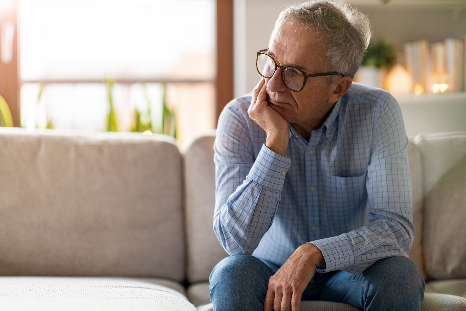 older man sits on couch