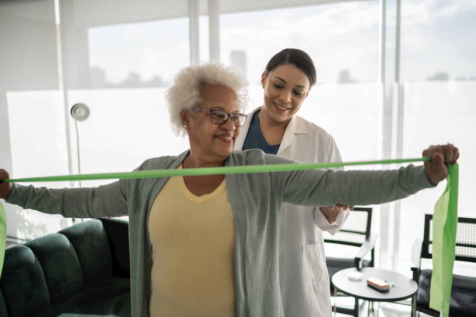 physical therapist helping woman with stretch-band
