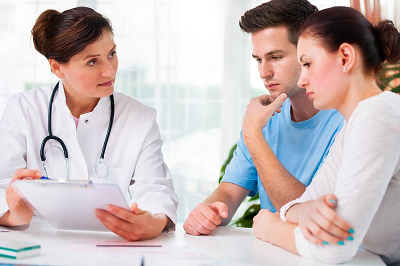 doctor discusses topics with a man and a woman