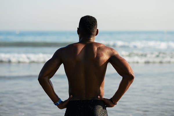man power-posing on beach