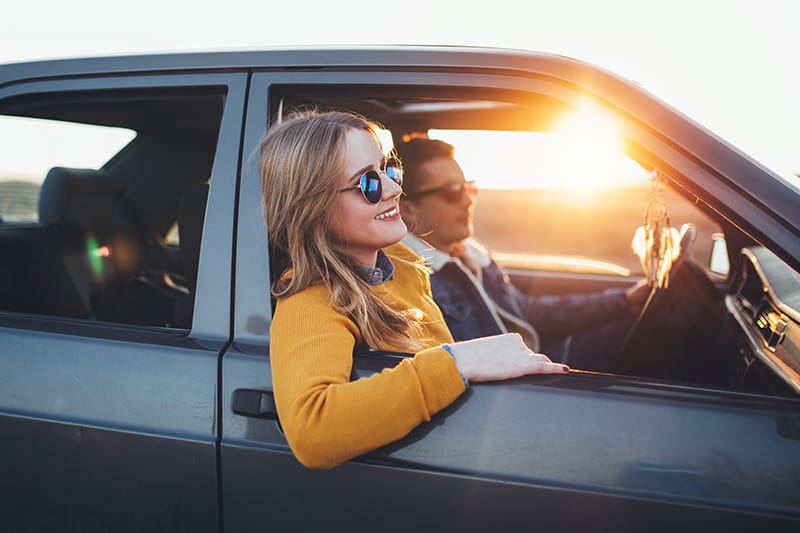 woman leans out of car window
