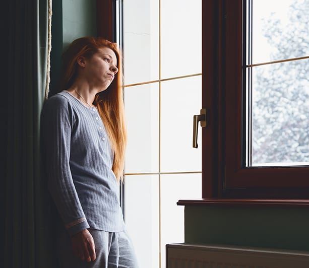 woman looks longingly out the window