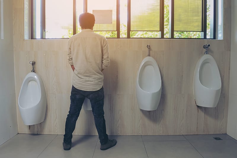 man standing at the urinal