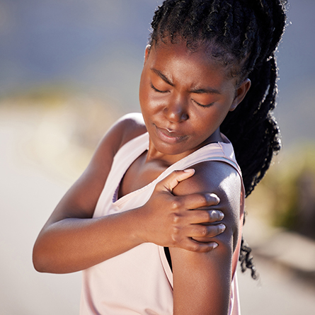 Active woman holding her shoulder in pain