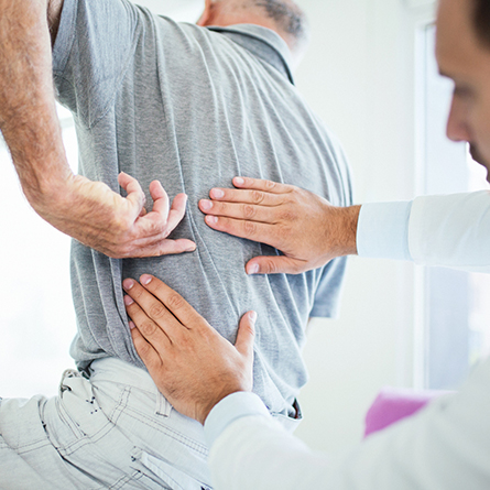 Doctor checking a patients back