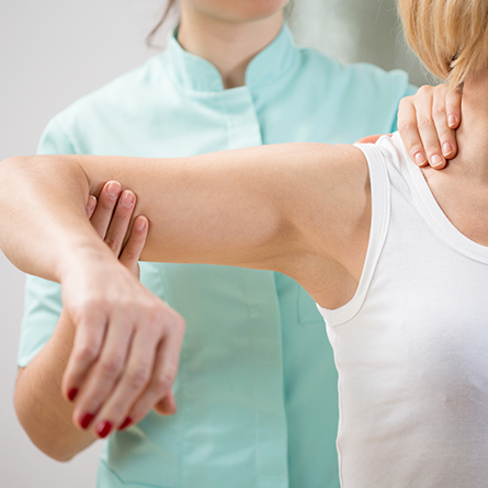 Physical Therapist working on patients shoulder