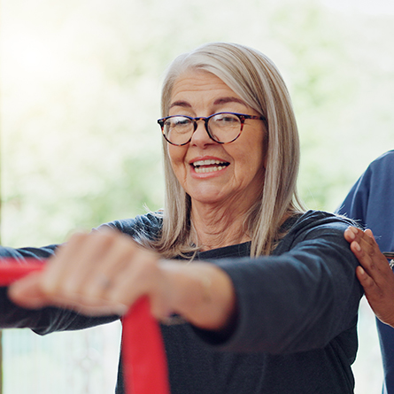 Woman doing a PT exercise with a band in her hands