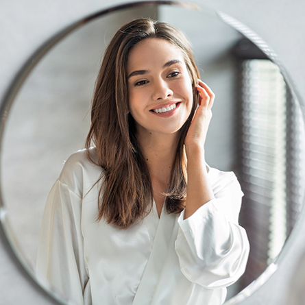 woman admires skin in mirror