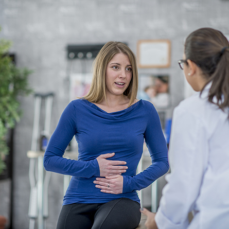 woman with stomach pain consulting doctor