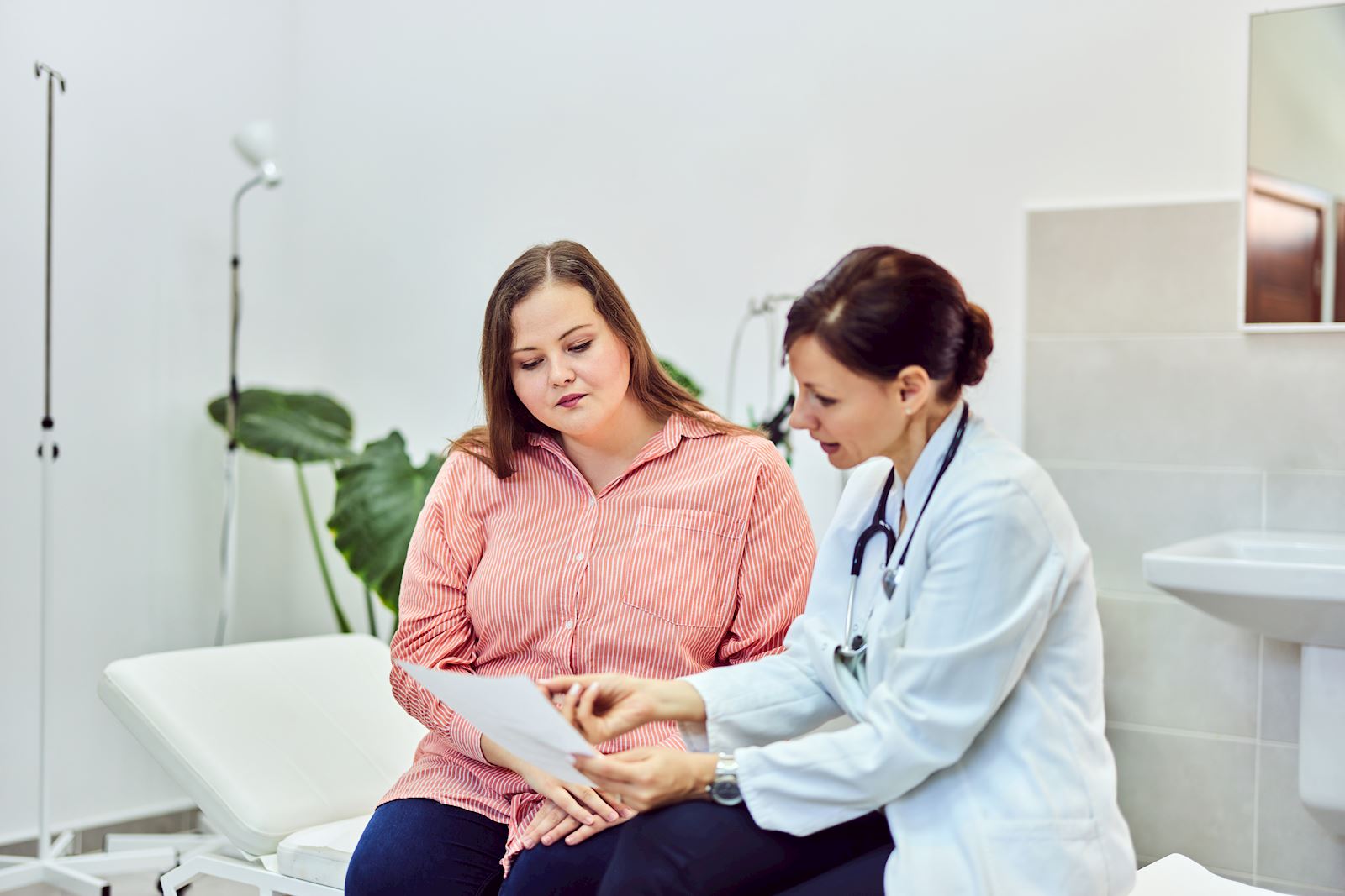 woman reviewing information with doctor in exam room