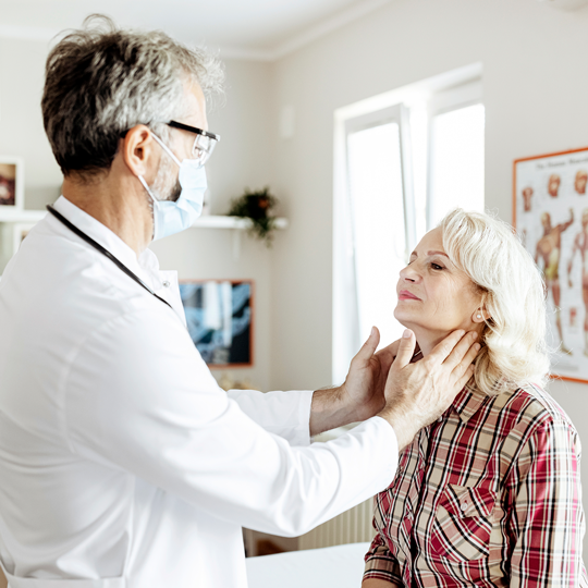 Doctor checking patient's neck