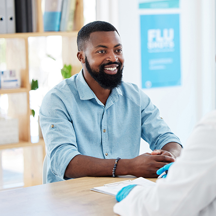 Man smiling while talking to a doctor
