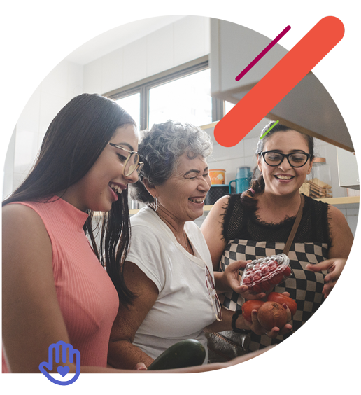 Three women laughing and cooking together