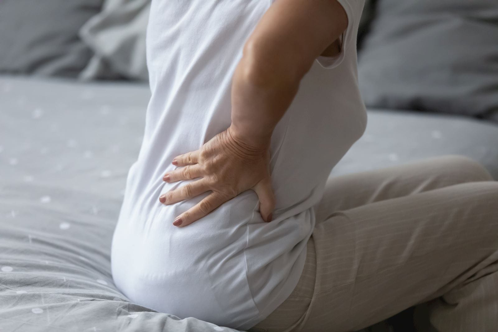 person holding their backside in pain